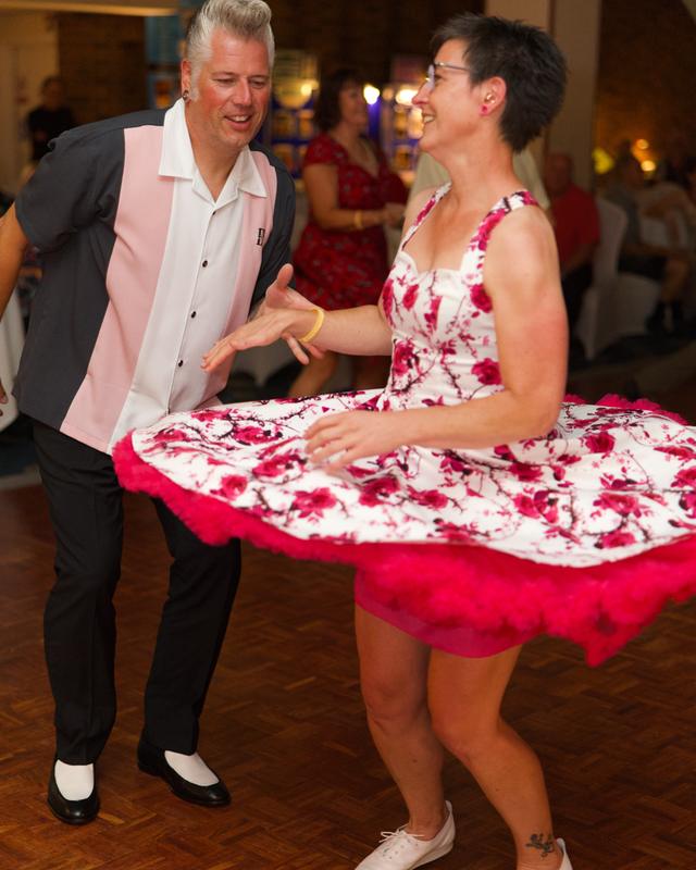 A dancer twirls a pink petticoat on the dance floor
