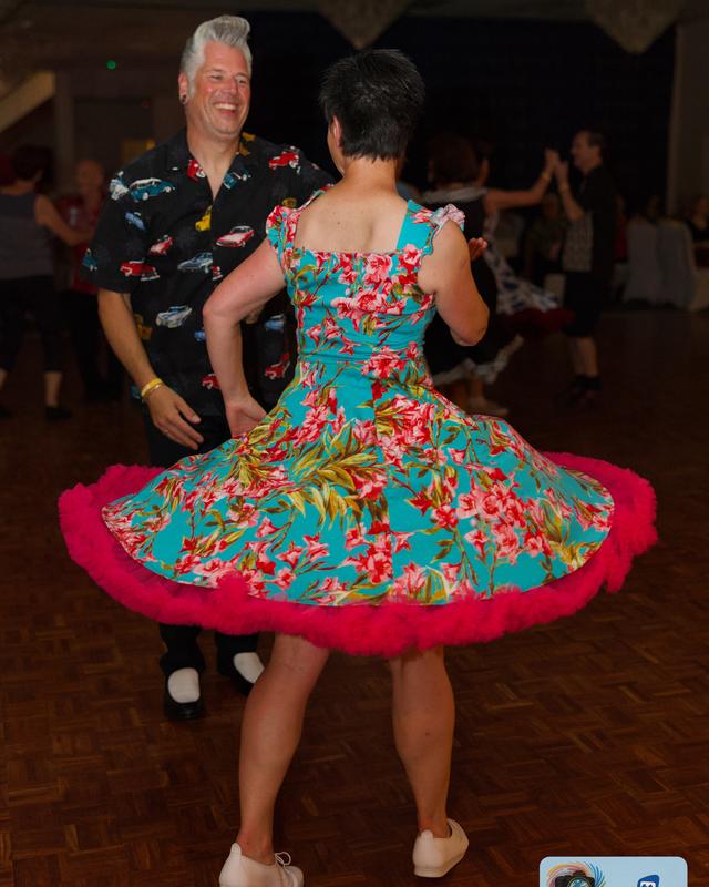 A turquoise floral dress mid-spin